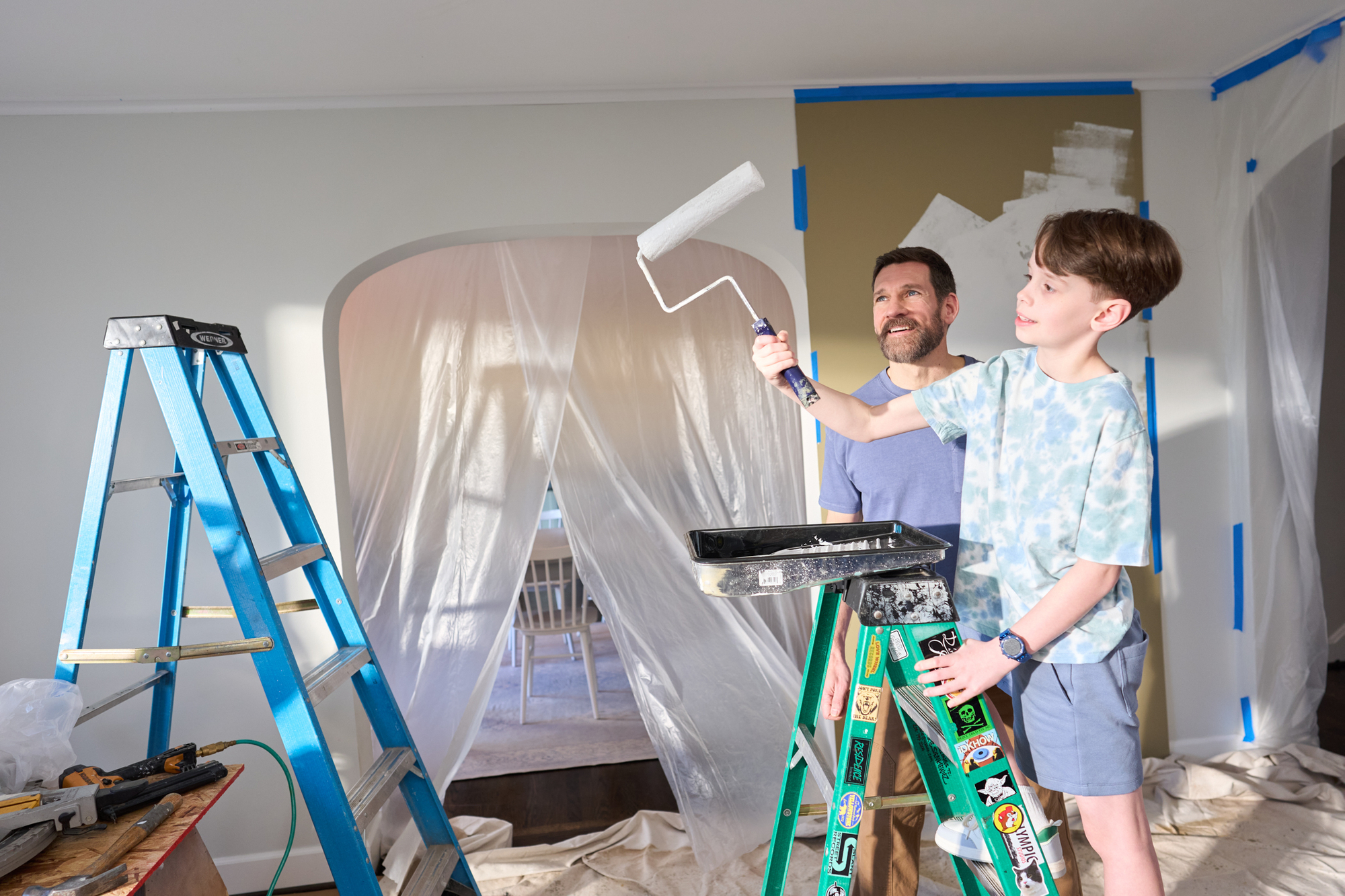 a dad and his young son paint their new home Family Home Renovations