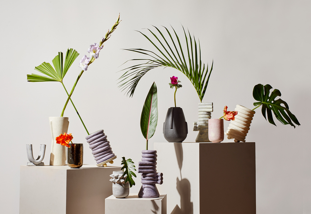 Curation of art vases with large tropical leaves