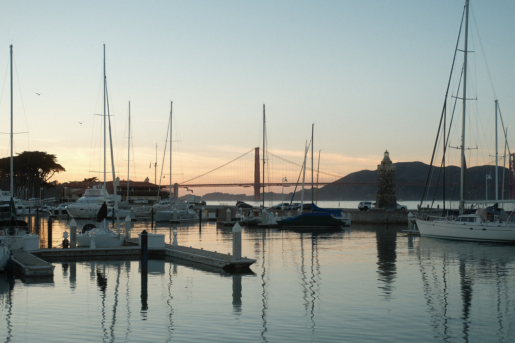 the sun rises over the boat marina 