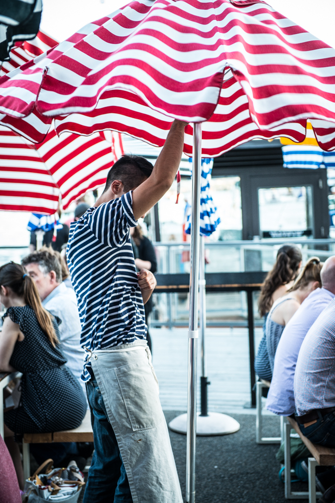 Preparing for the weather to keep the restaurant busy, hard working service industry workers, stripes and more stripes Outdoor seating in a lively city