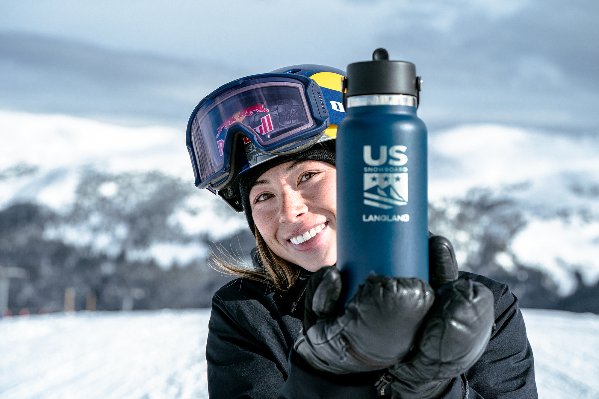 woman holds her hydroflask up to camera 