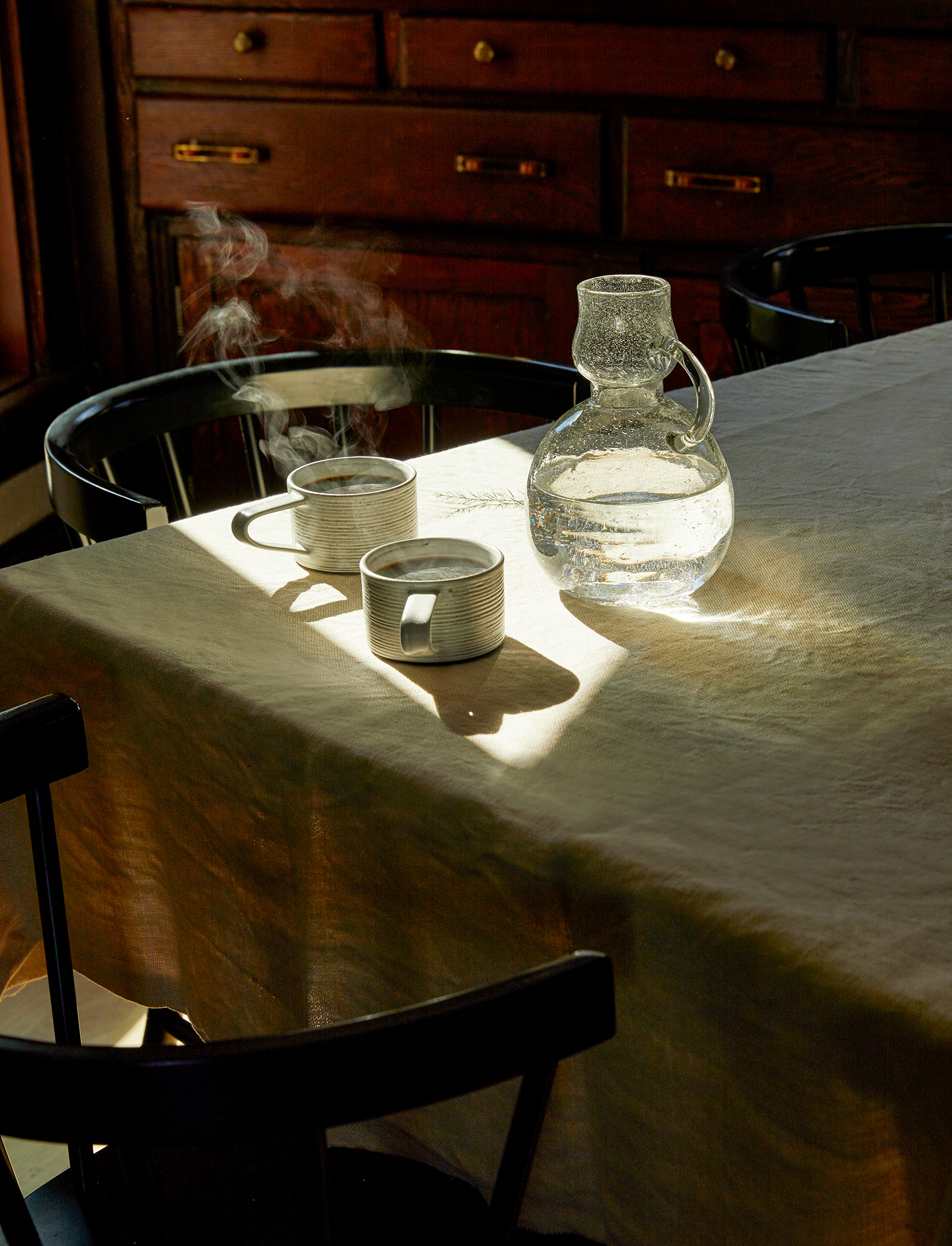Two mugs and a bubbled glass water vessel