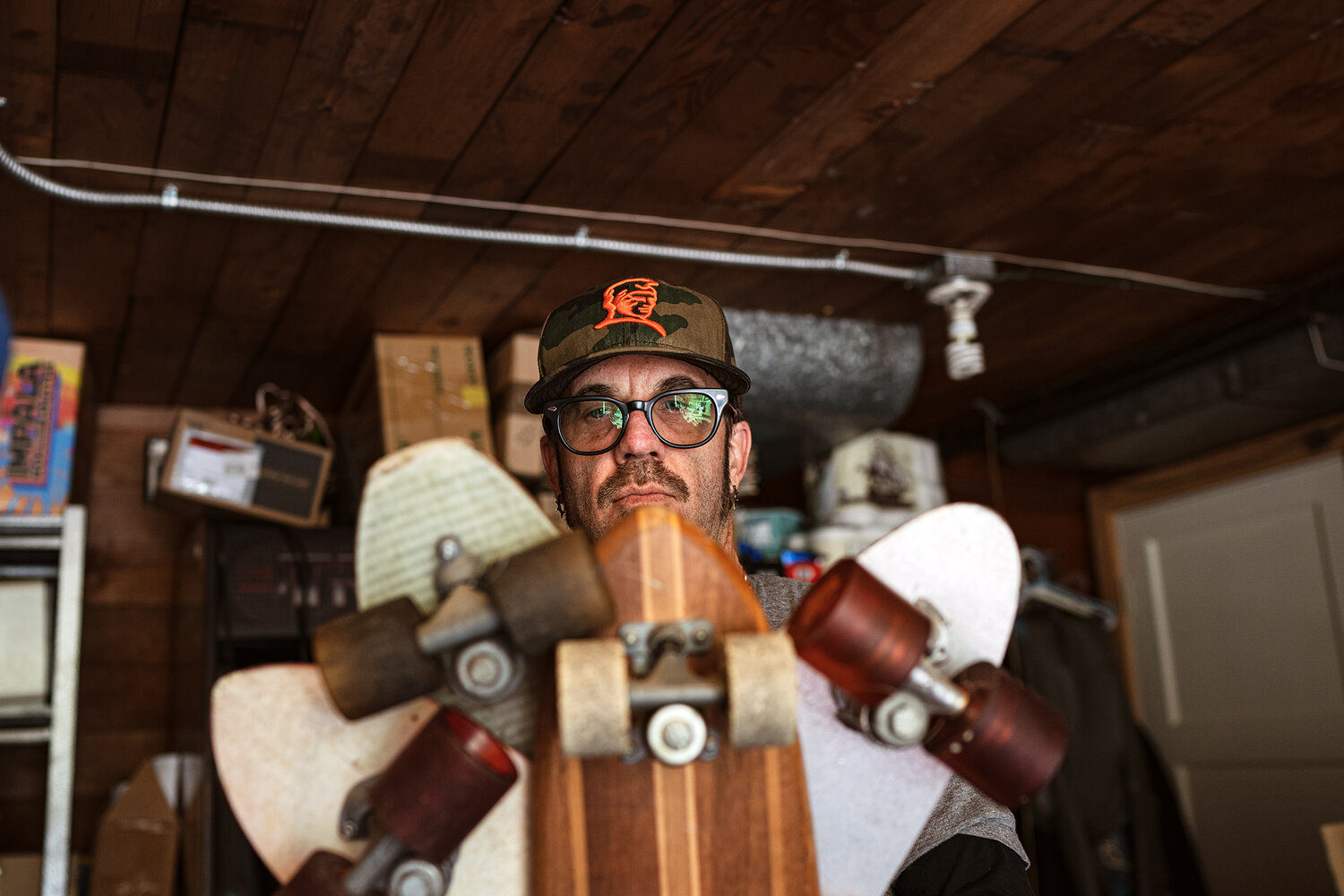 man poses with skateboards and long boards 