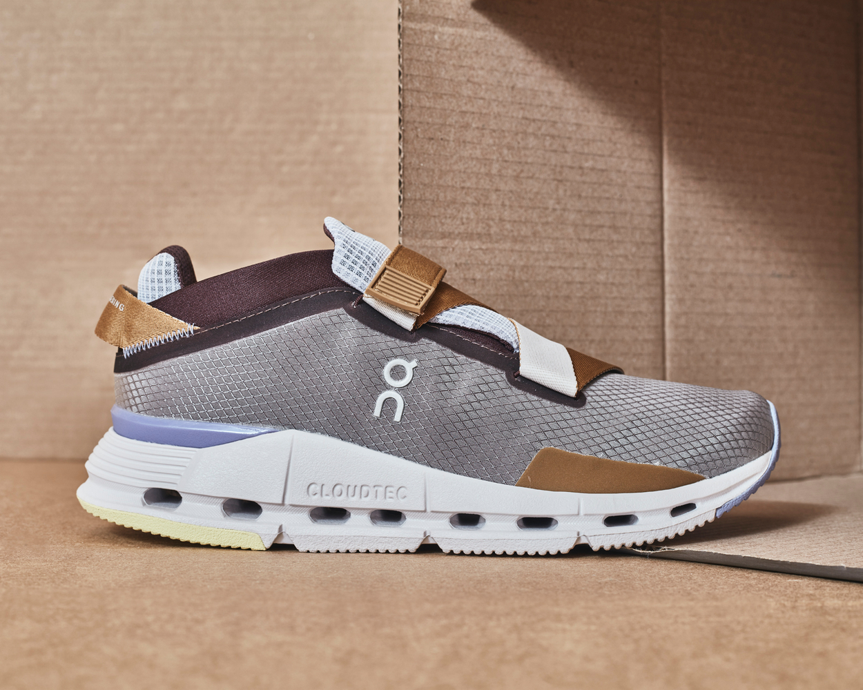 How to show off unique shoe features in athletic wear advertising, multi-colored earth tones, grey, brown, purple and light yellow , Swiss engineered Grey walking shoe with textile detail