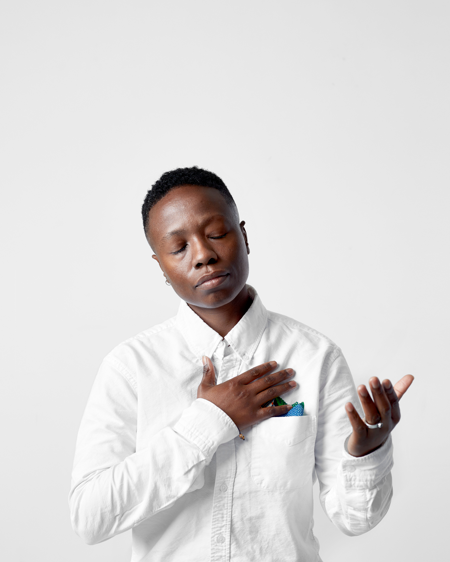 young man in all white photograpehed on white backdrop 