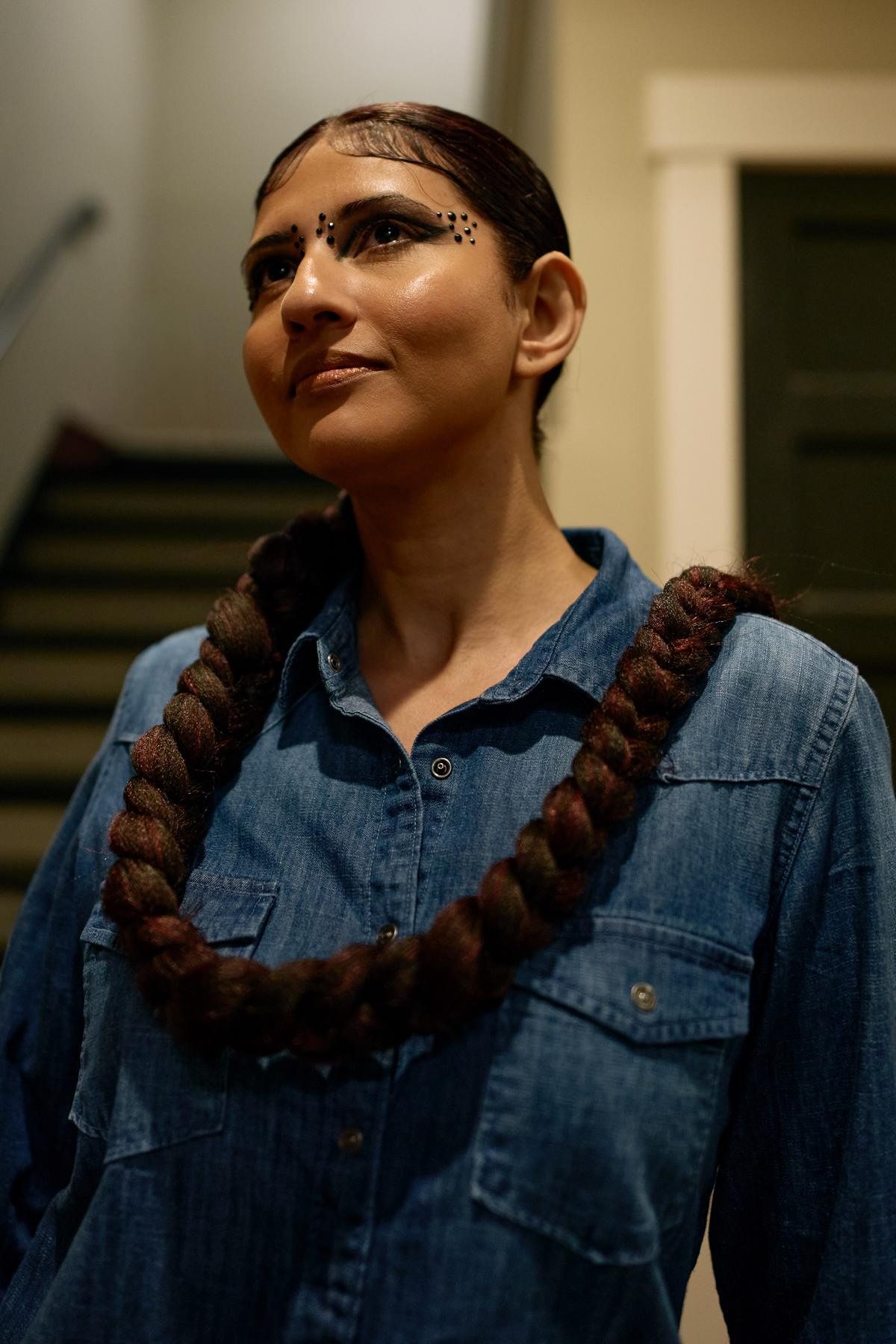woman with long braid wrapped around her neck like a scarf 