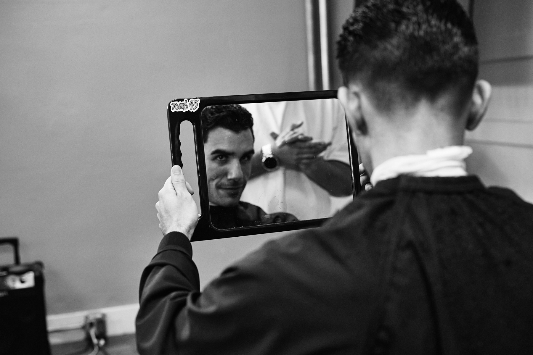male model checks his new haircut out in a mirror backstage at the la paisa fashion show 