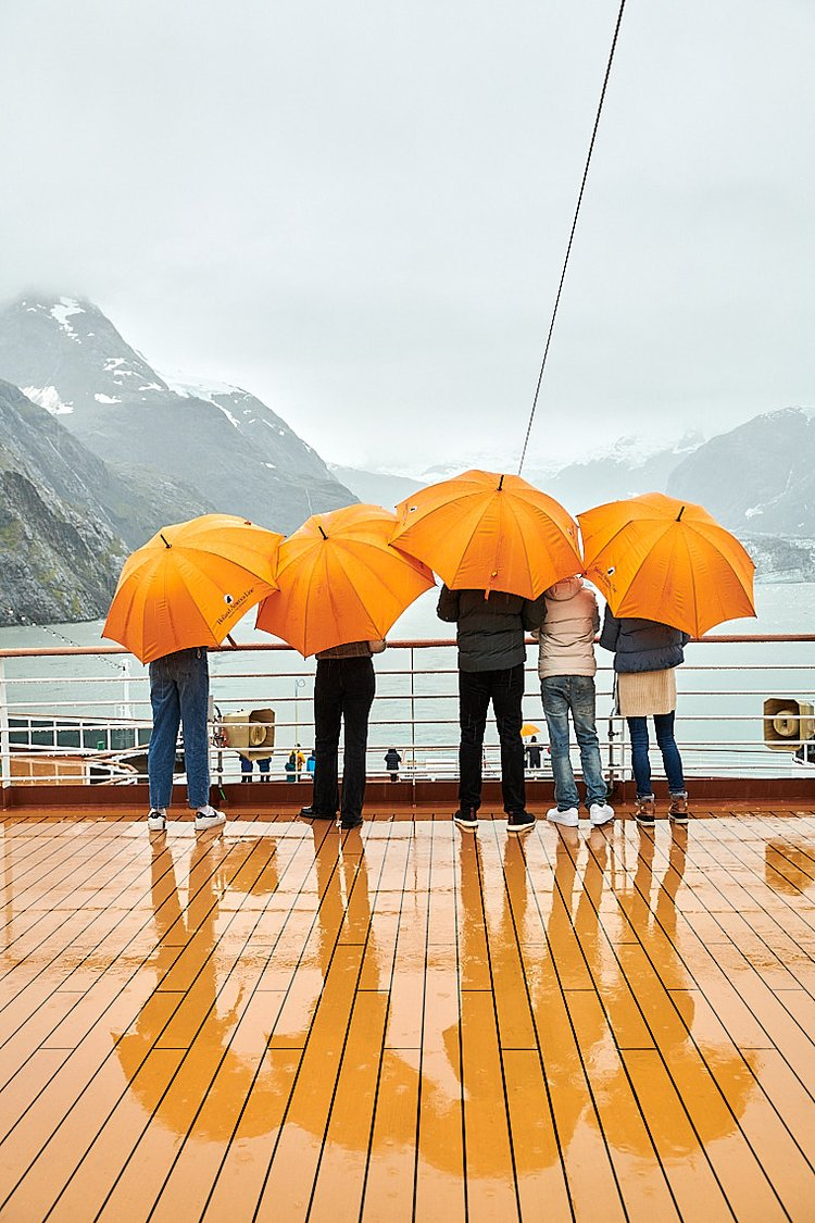 Five people stand on the deck of a boat