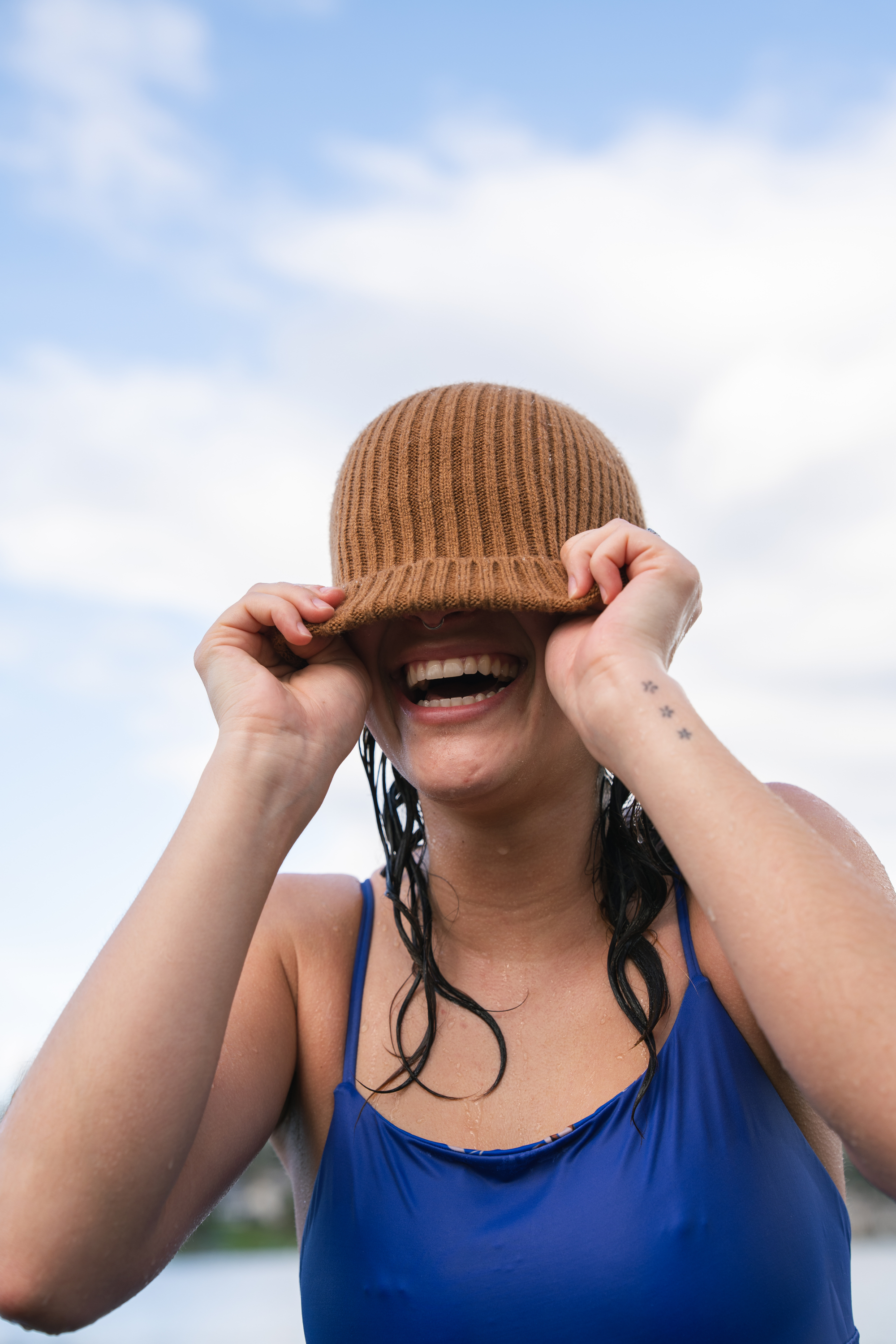 young woman in blue bathing suit and yellow beanie 