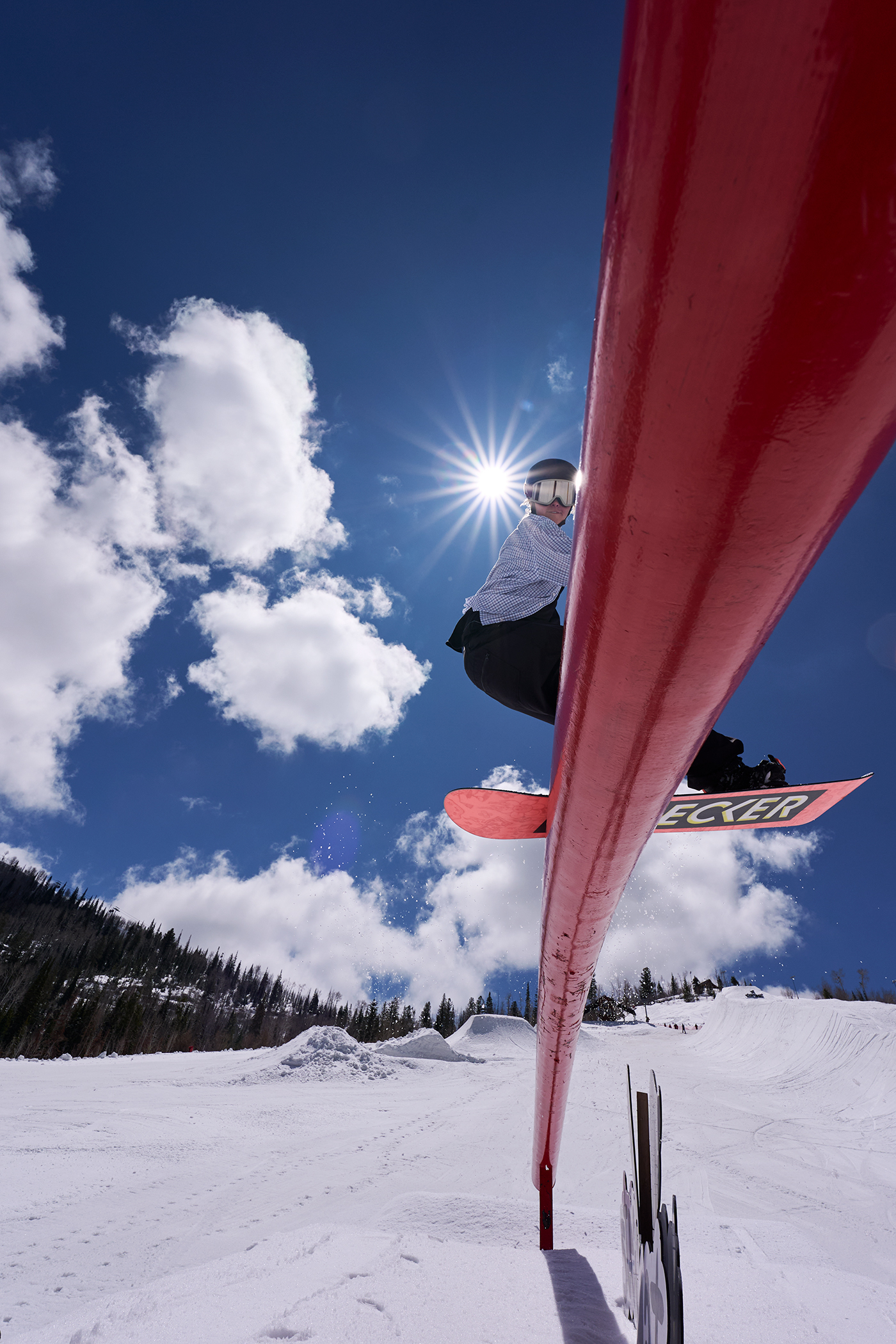 snowboarder rides a red rail in the winter snow riding the rails