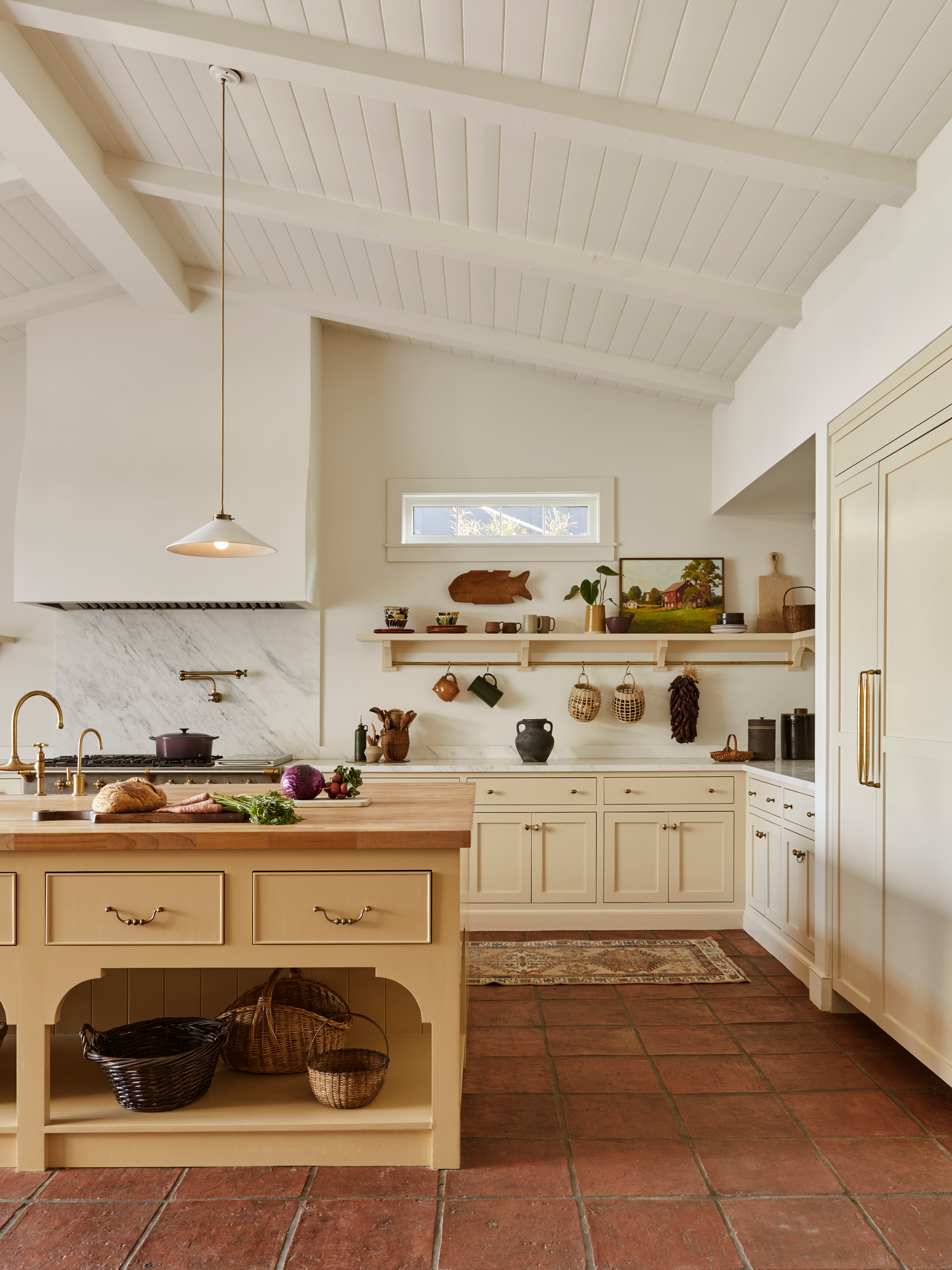 gorgeous white kitche nwith red tile floor 