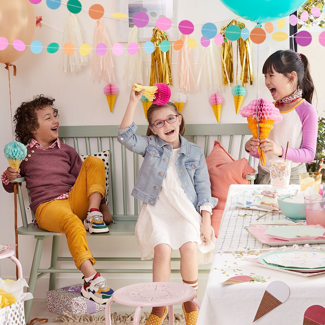 three kids laughing at a birthday party
