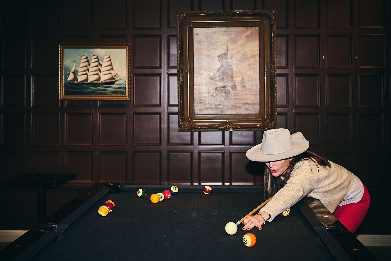 ornate exclusive club woman plays pool at the rainier club in seattle