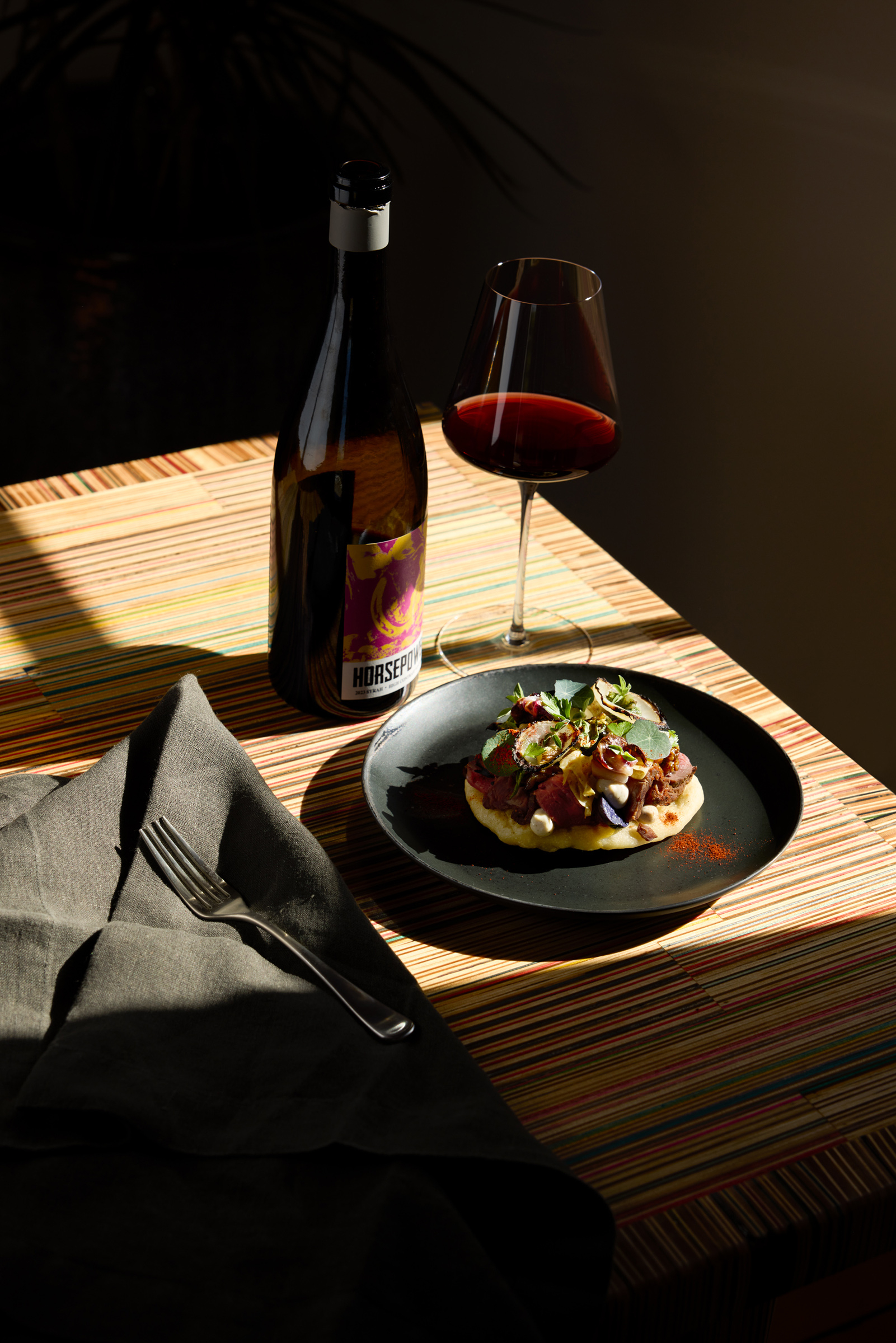 elegany plated meal with glass of red wine