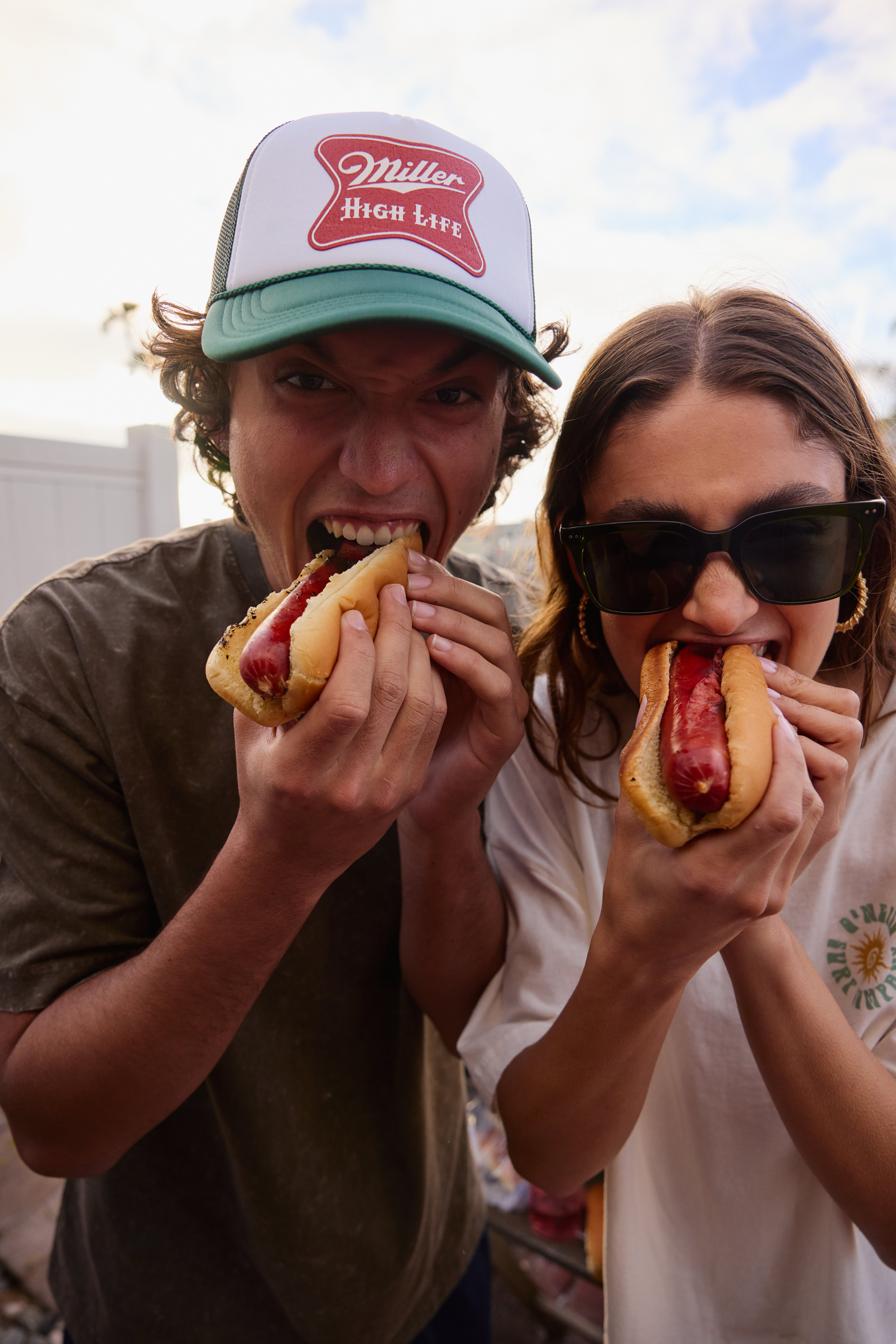 friends eat hot dogs together 