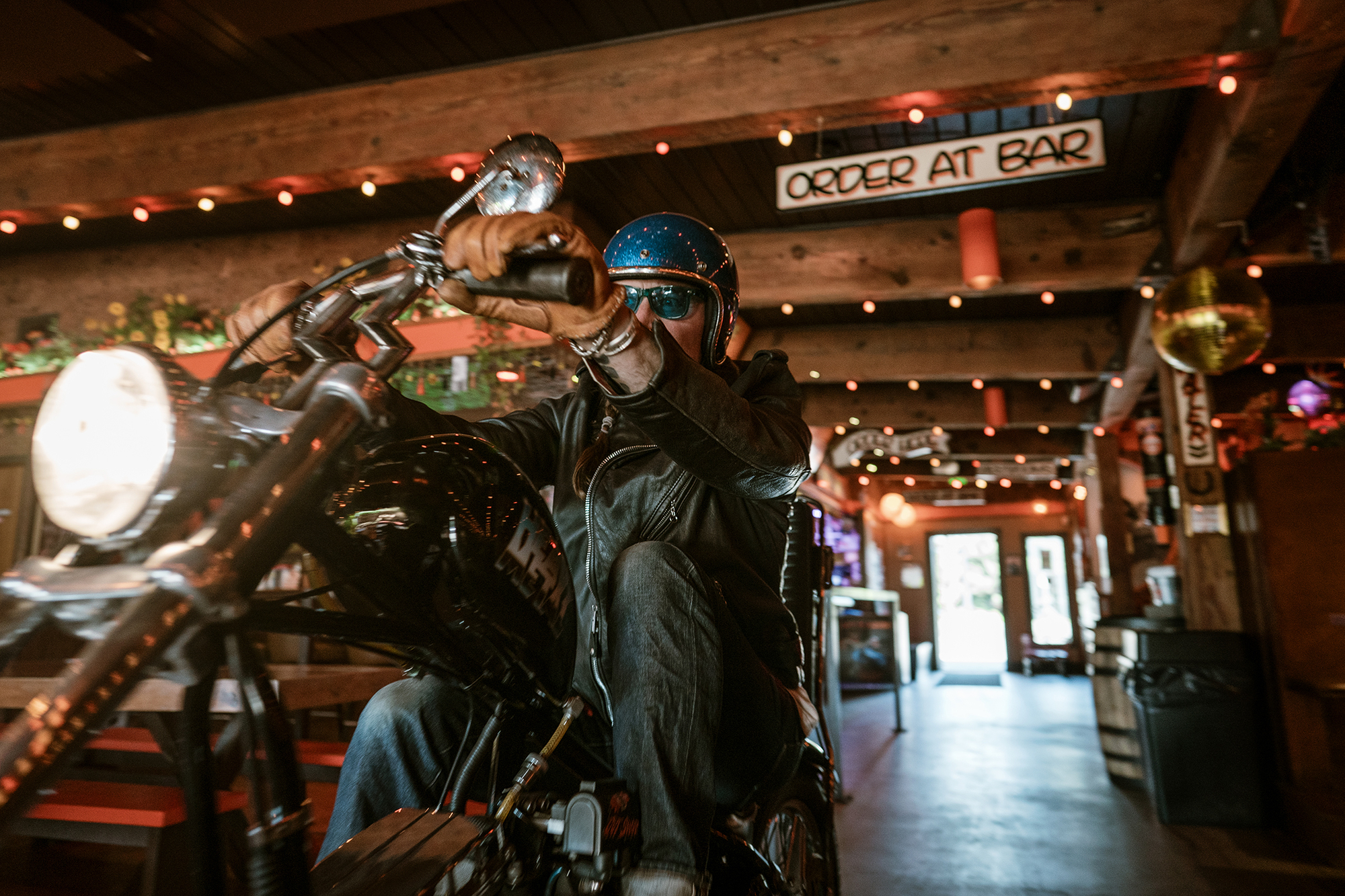 Guy riding through the bar on motorcycle