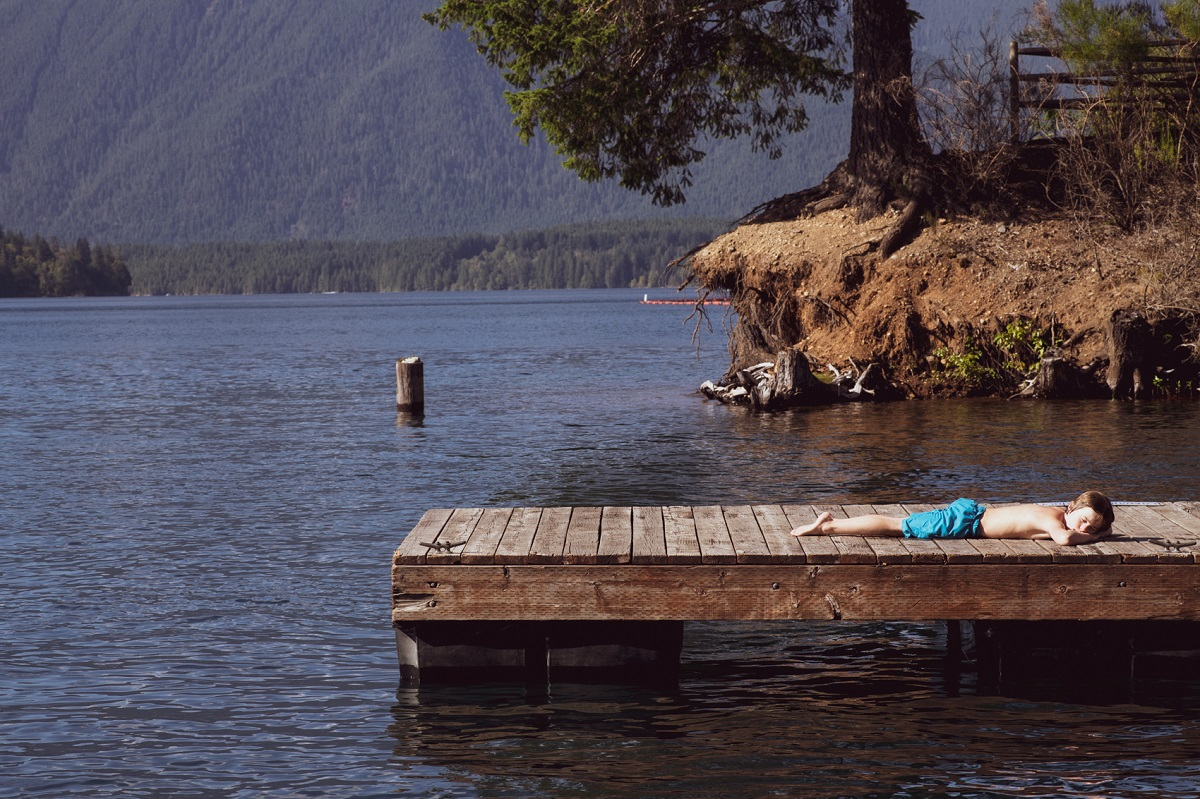 Boy tanning on pier 