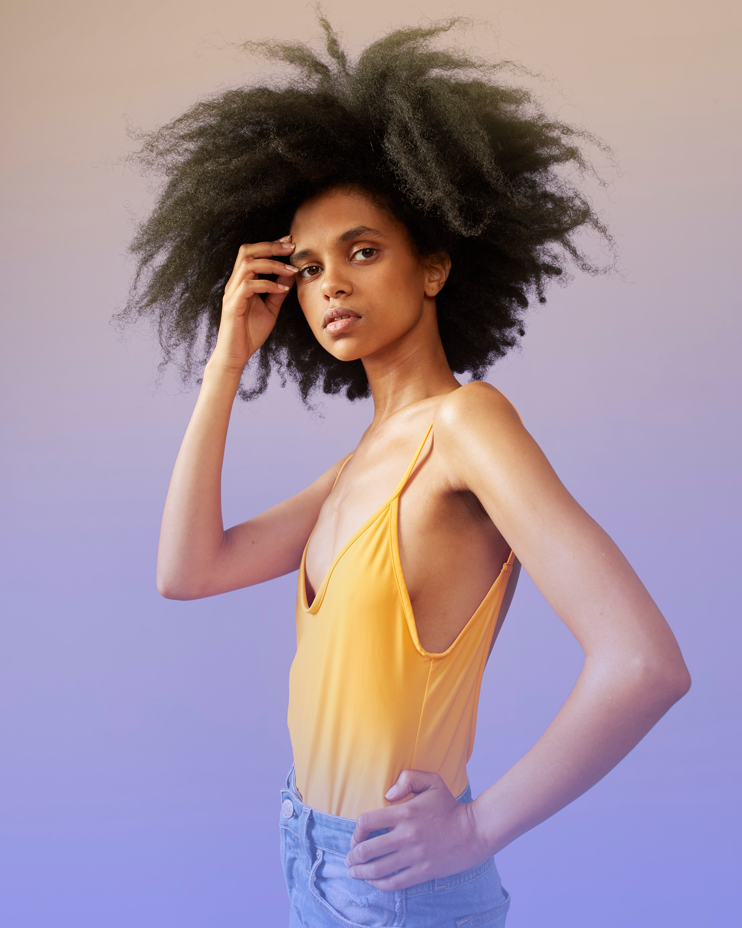 young woman poses in front of ombre backdrop 