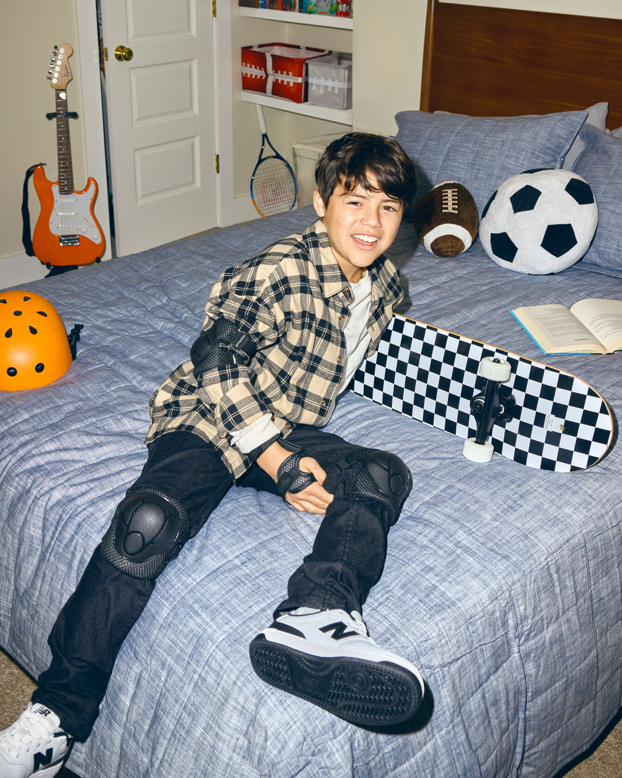 young boy chills with skateboard on bed 