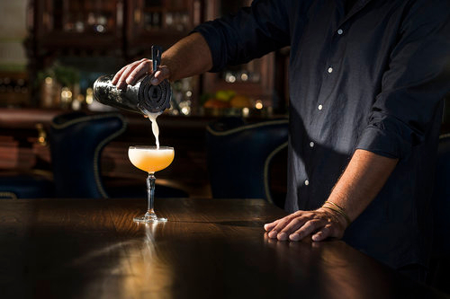 a bartender pours a kilbeggan brosna sour cocktail 
