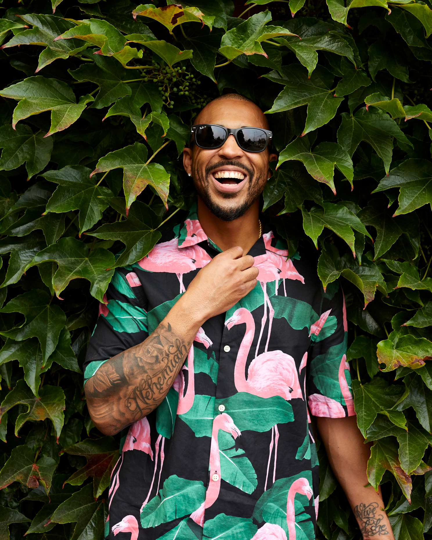 young black man in flamingo shirt laughs 