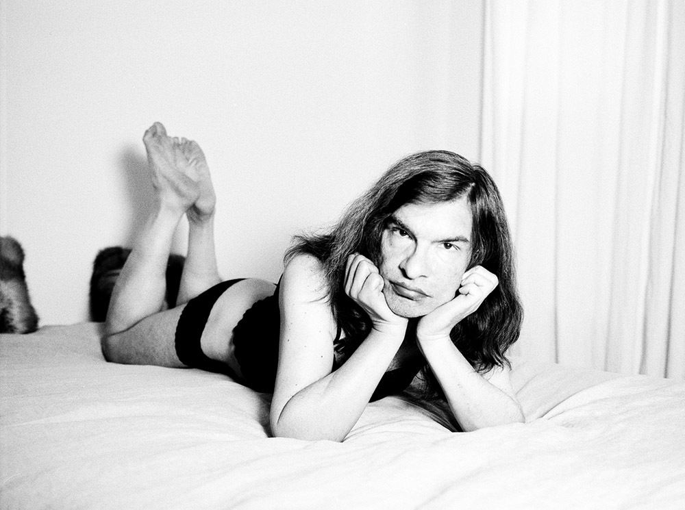 Chet lying on bed in black lingerie – portrait by Micha Warren
