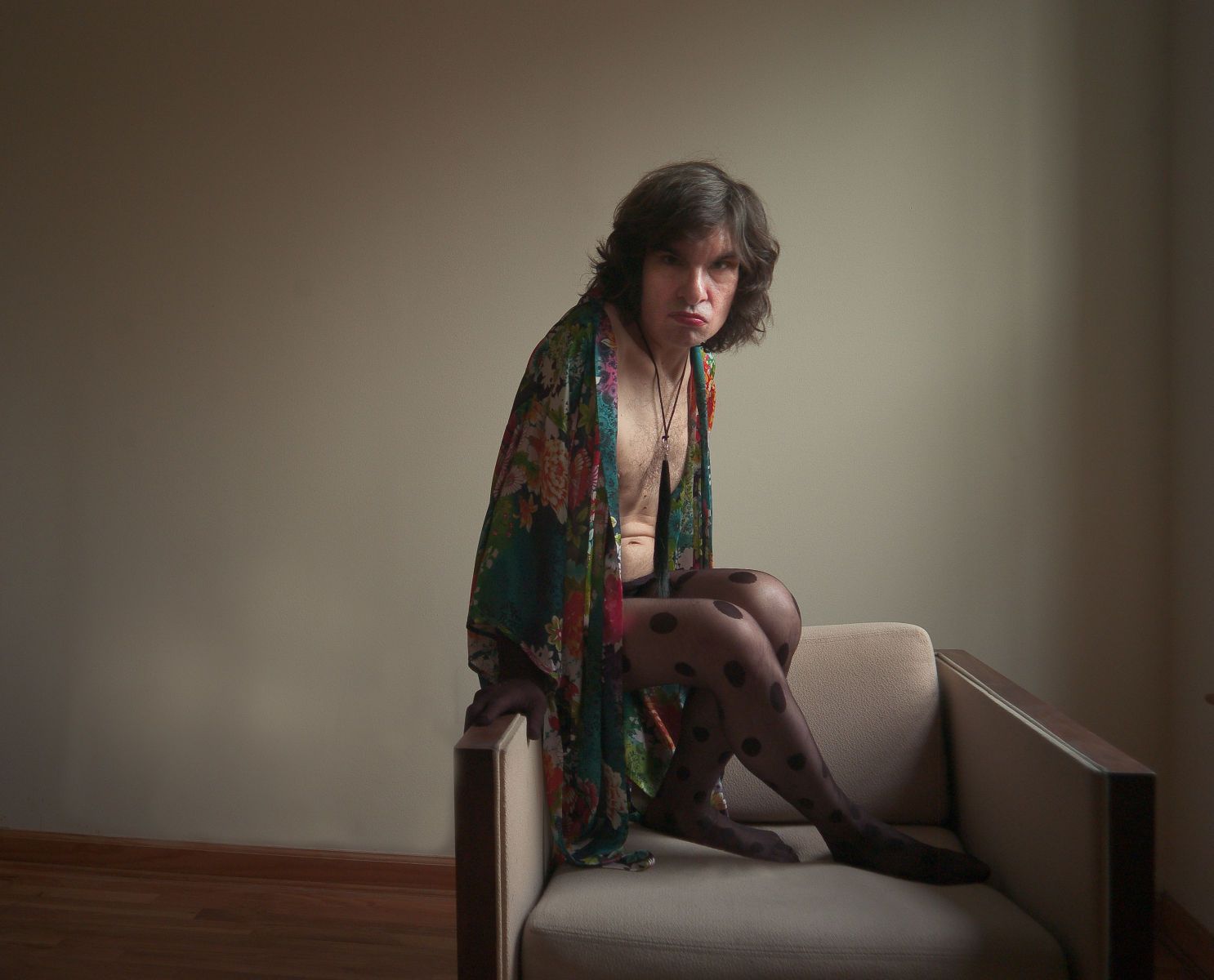 Chet seated in floral robe and polka dot stockings – portrait by Micha Warren