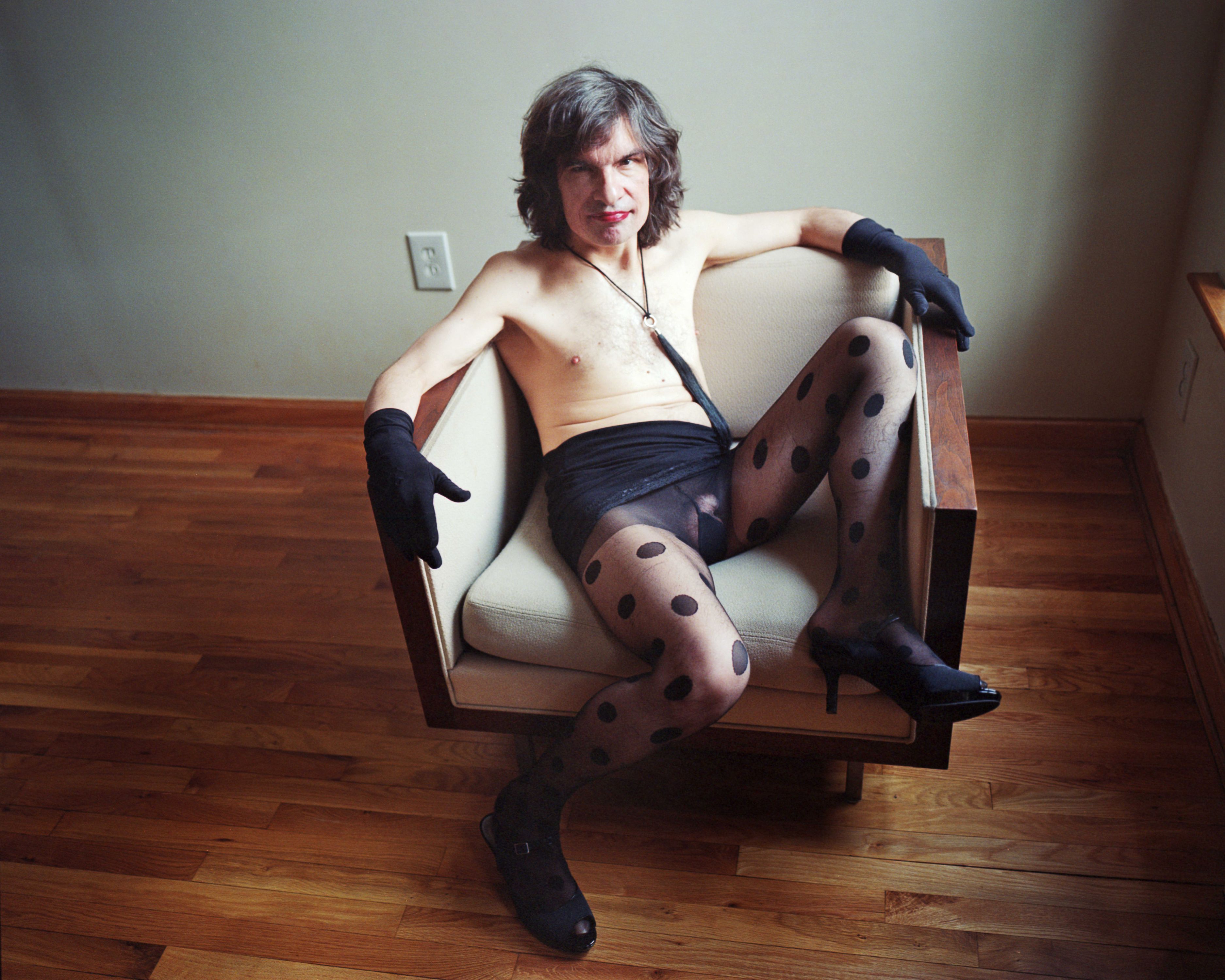 Chet sitting in chair wearing black polka-dot stockings – portrait by Micha Warren