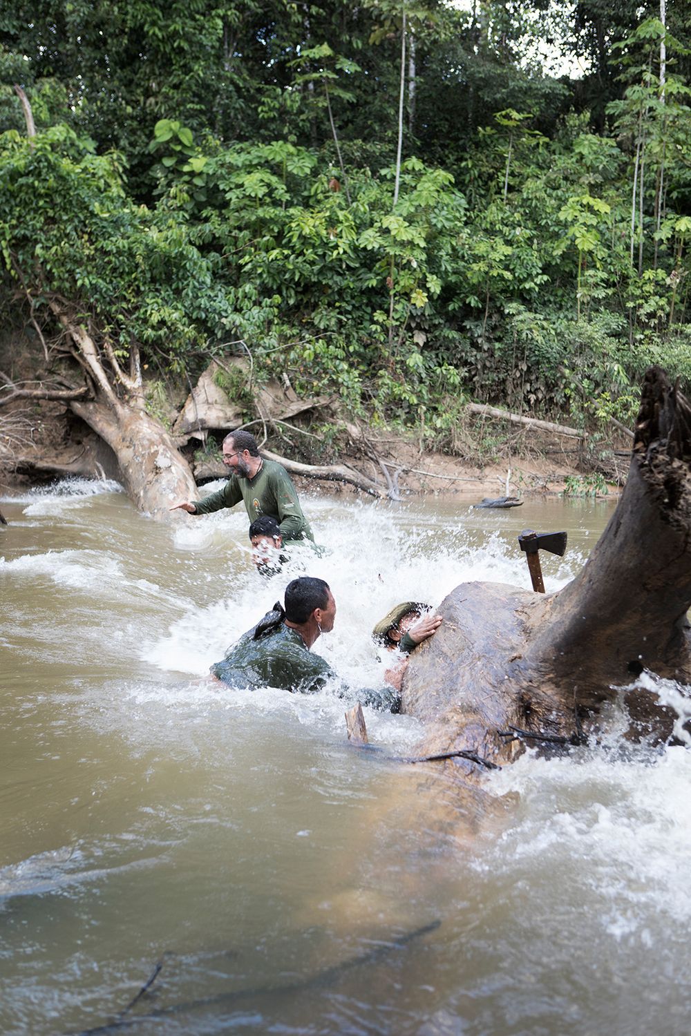 Members of the FUNAI expedition team clear the fallen tree which was preventing the navigation up the Rio Sapota towards the starting point of the expedition to trace the movements of uncontatced people. After cutting into the fallen tree for 1 1/2 hours team members stood on the tree to finally move it. The tree broke and the team members crashed into the river.
Amazon