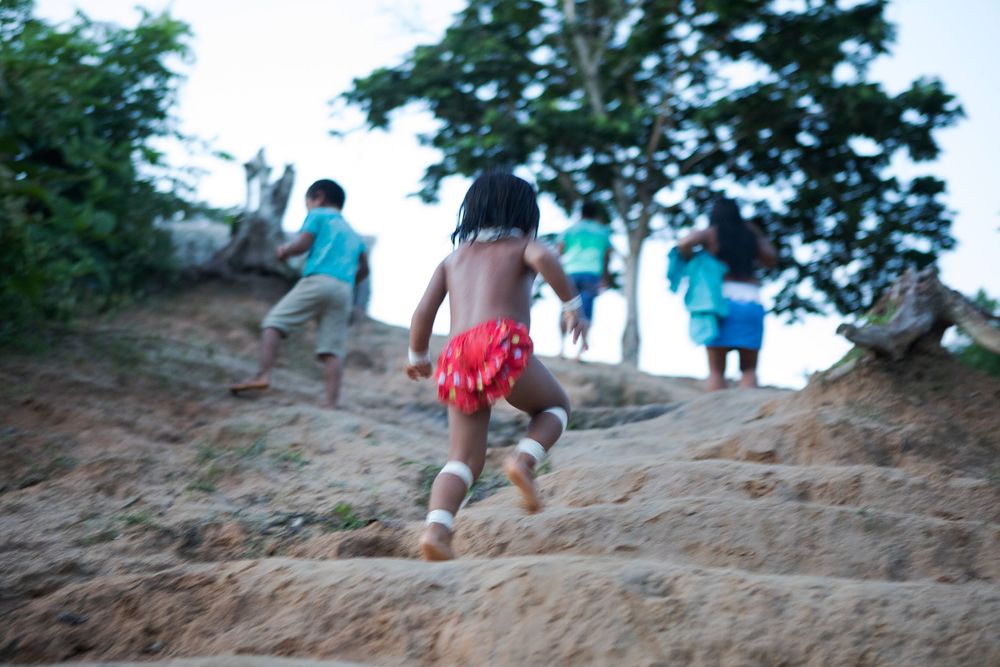 Marubo children run back to the village after bathing in the river, Rio Novo. Amazon