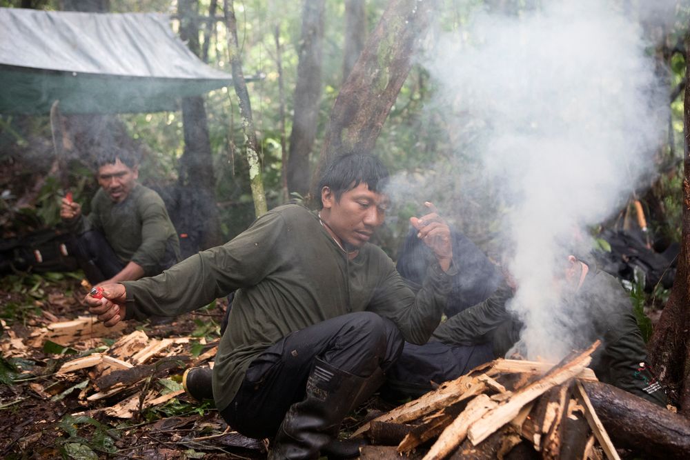Preparing the camp during FUNAI expedition within the Vale do Javari. Expedition leader Bruno Pereira is seen here preparing the camp fire with Korubo tribe members Lëyu Korubo, Takvan Korubo
(rear with machettee) and young korubo boy Xikxuvo Vakwë. Part of the r Amazon