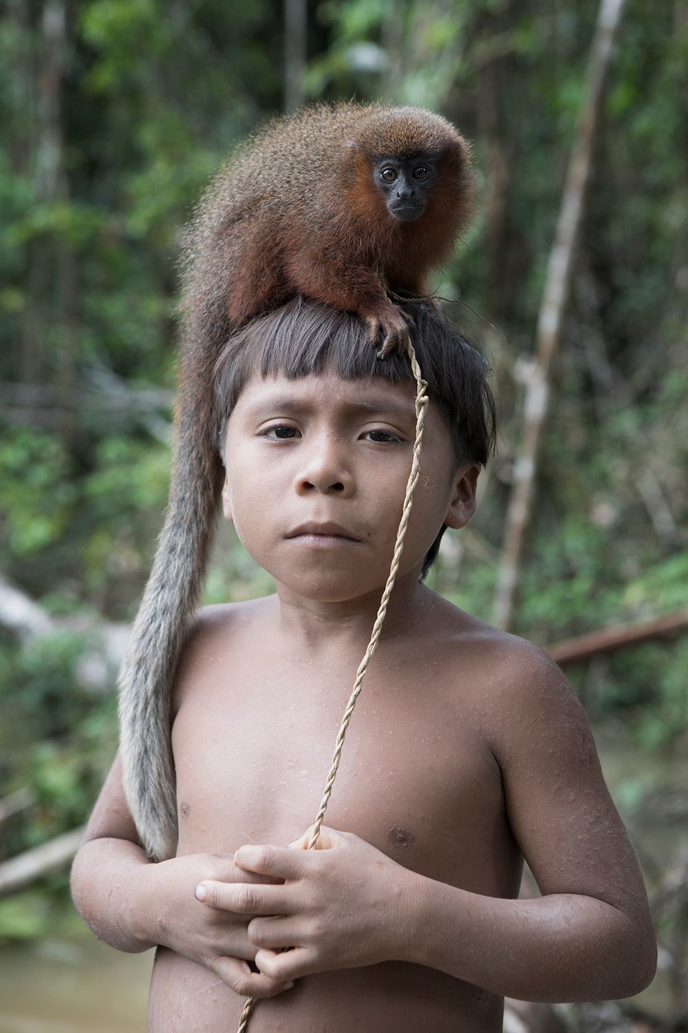 Young Korubo boy Txipu Wanka with his pet monkey. Amazon