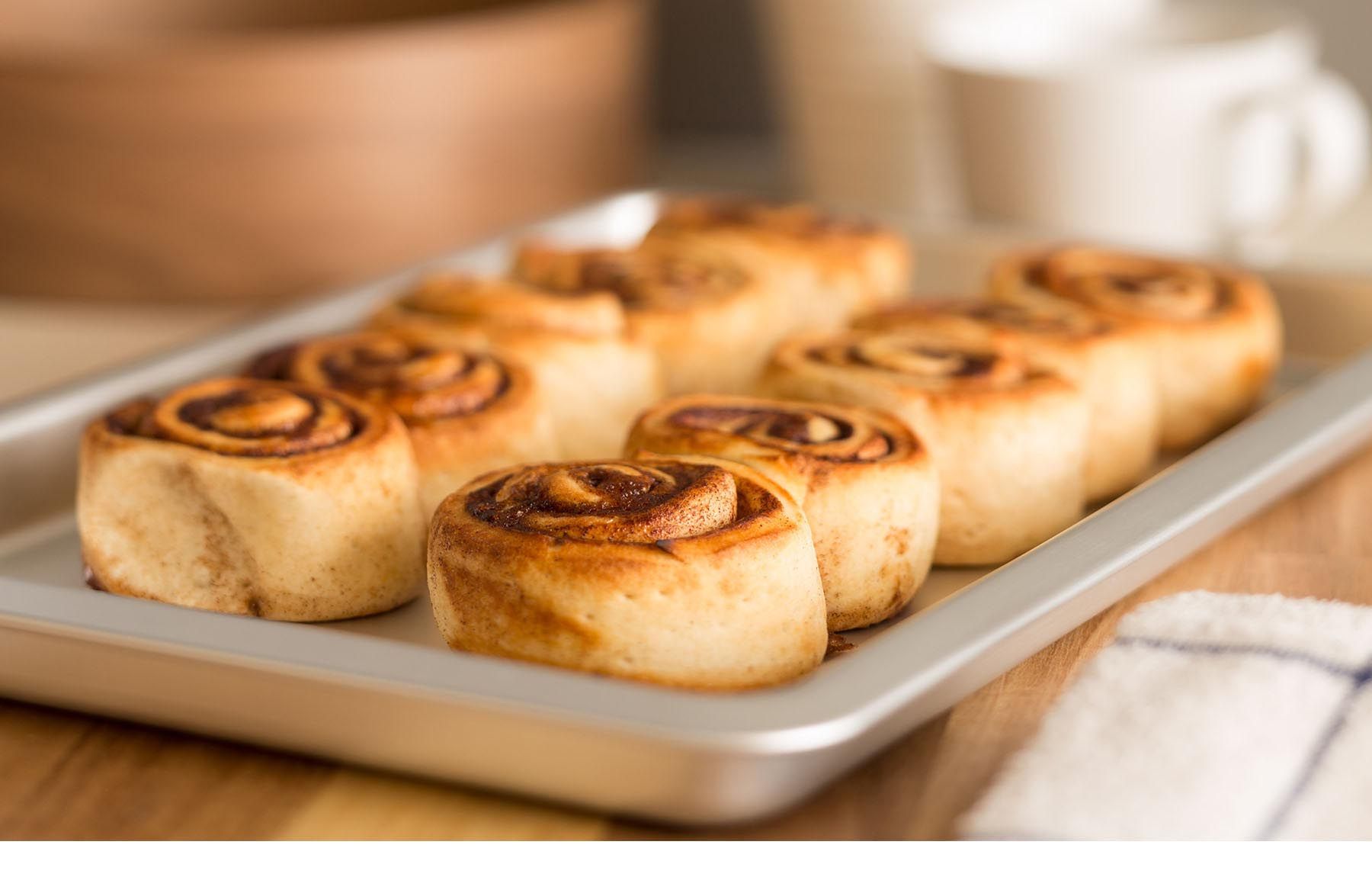 Commercial food photography of freshly baked cinnamon rolls on a baking sheet