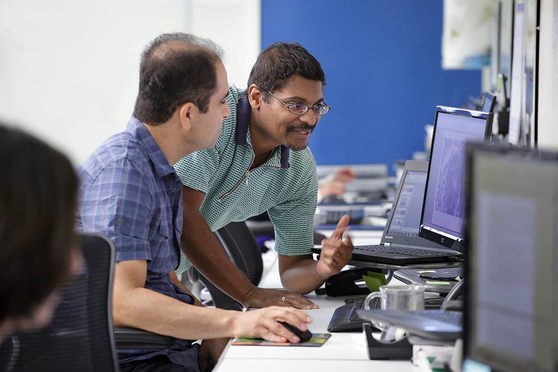 Two scientists collaborating at a computer workstation