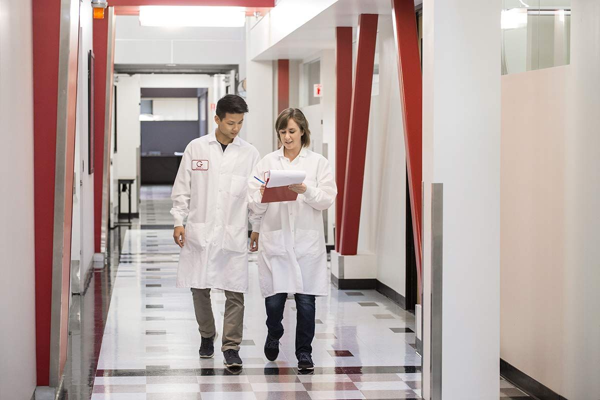 Biotech Laboratory Scientists Collaborating in Research Facility Corridor