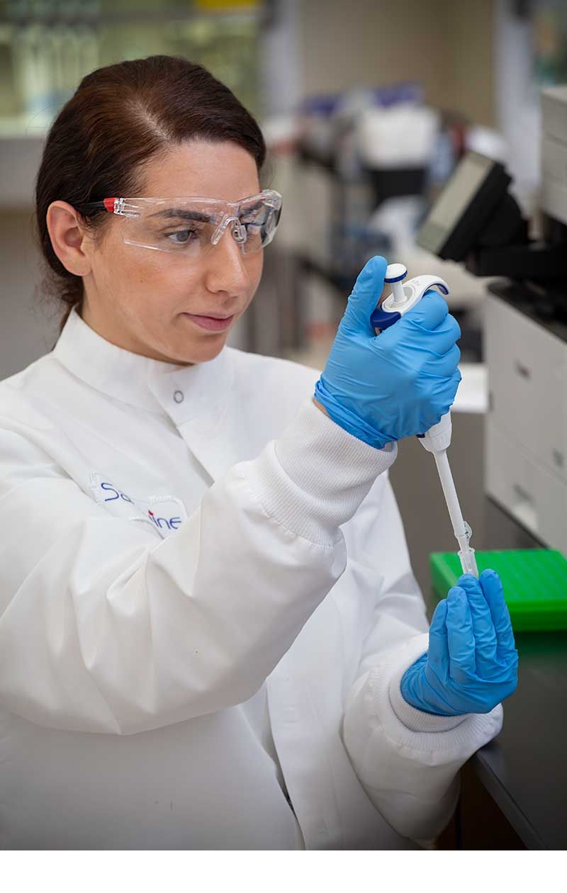 Commercial lifestyle photography of a scientist using a pipette in a biotech laboratory