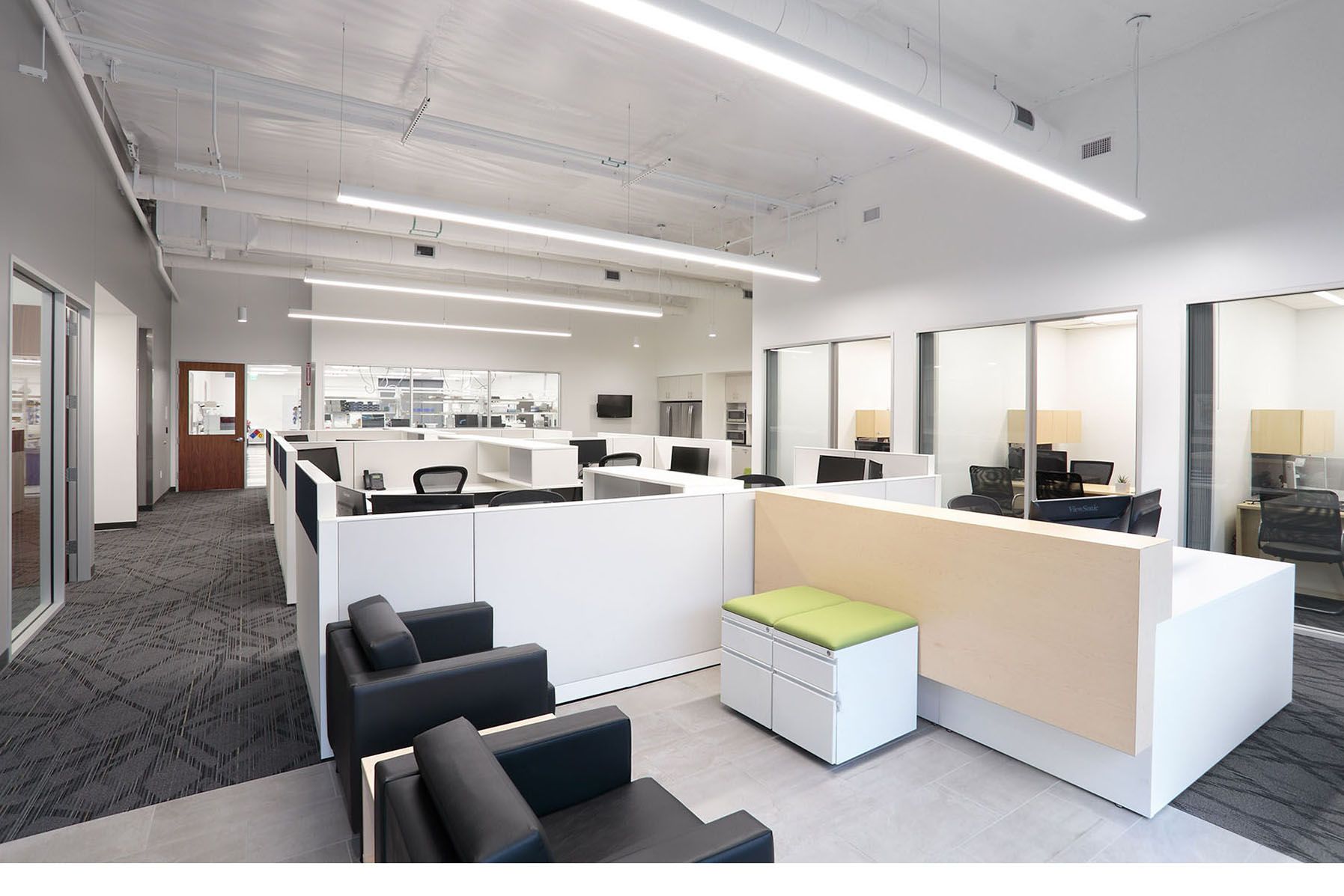 Modern corporate open office space with cubicles and reception seating