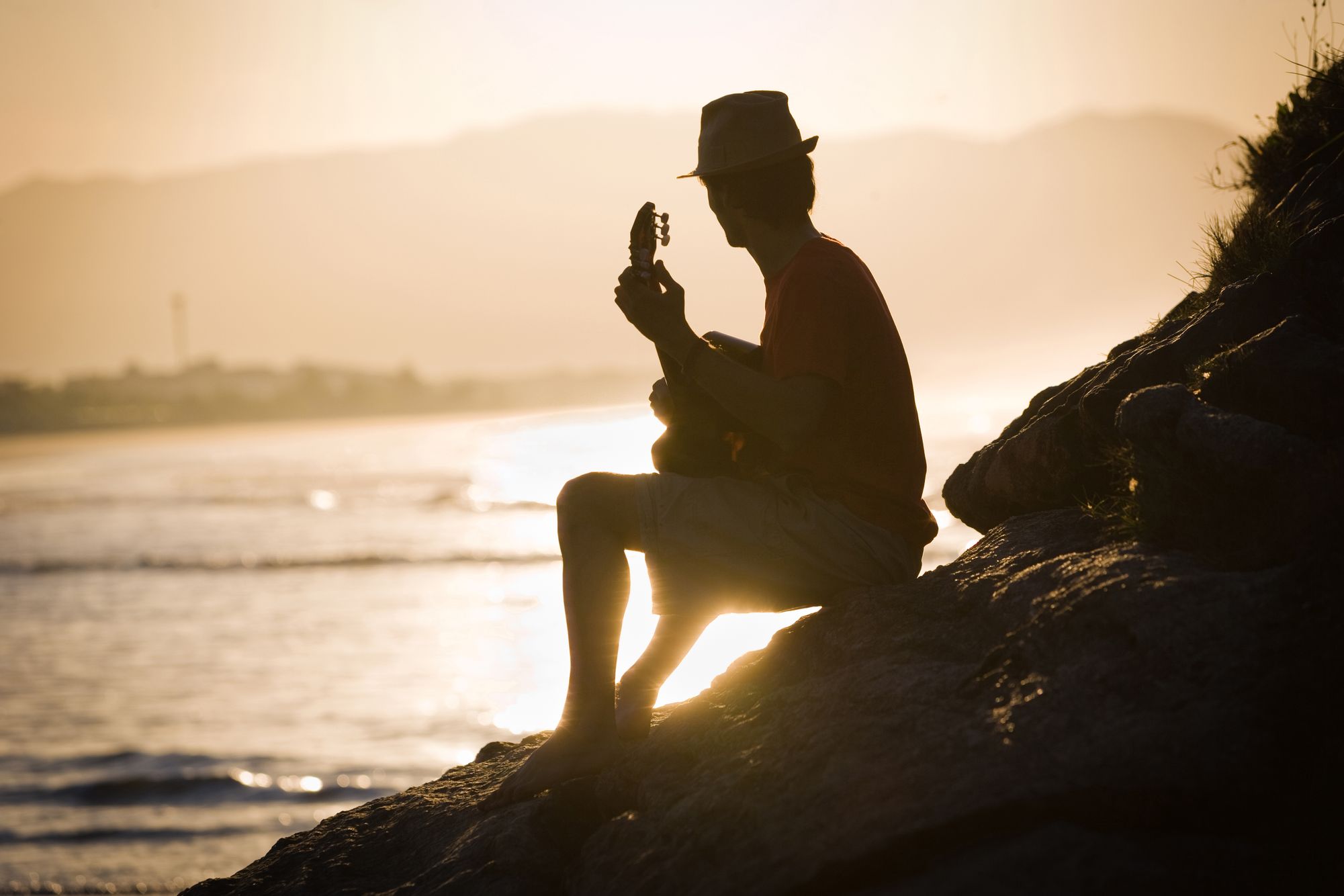 Man with guitar at beach