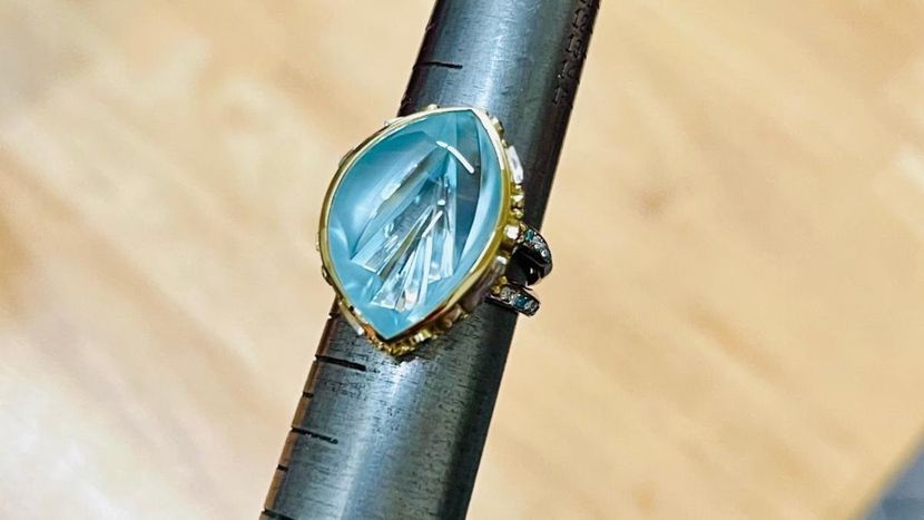 18k yellow and white gold, natural blue topaz, white and blue diamonds, sizable. GLACIER FLOWER RING