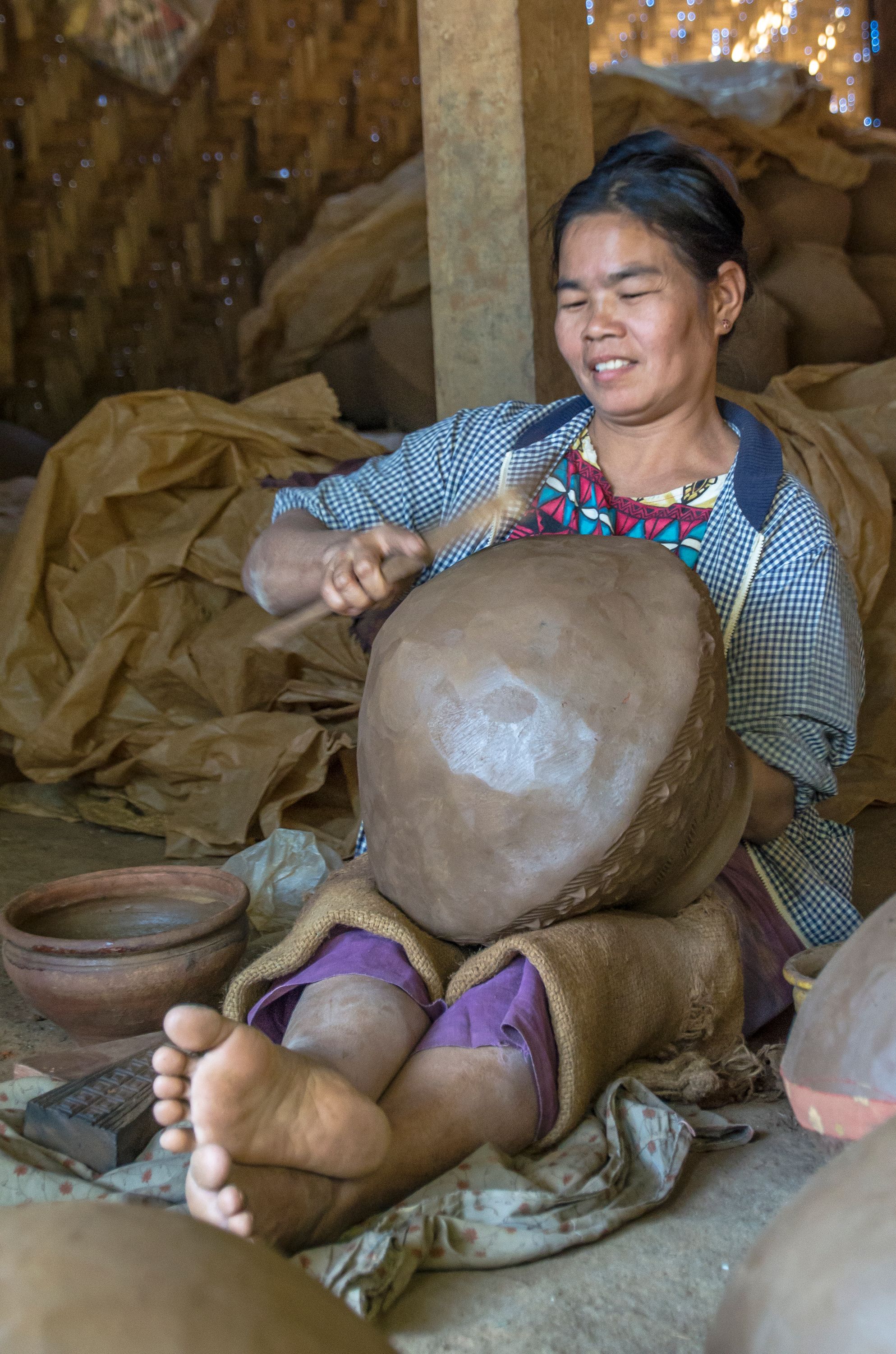 Woman shaping bowl, Myanmar