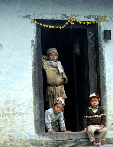 Boys in Phakding Nepal with house decorated for Mani Rimdu Festival 1kids_doorway_nepal