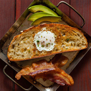 Fried egg over sourdough toast with bacon and avocado Egg In A Basket