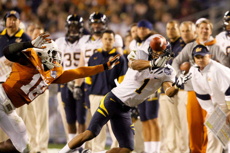 California Golden Bears wide receiver Marvin Jones (1) stretches out to make a catch while being defended by Texas Longhorns linebacker Emmanuel Acho (18). Texas beat Cal 21-10 to win the Bridgepoint Education Holiday Bowl at Qualcomm Stadium in San Diego, California. NCAA FOOTBALL: Bridgepoint Education Holiday Bowl - California v Texas