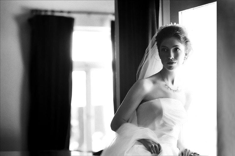 A bride  looks out the window on her wedding in Los Angeles wedding  photo