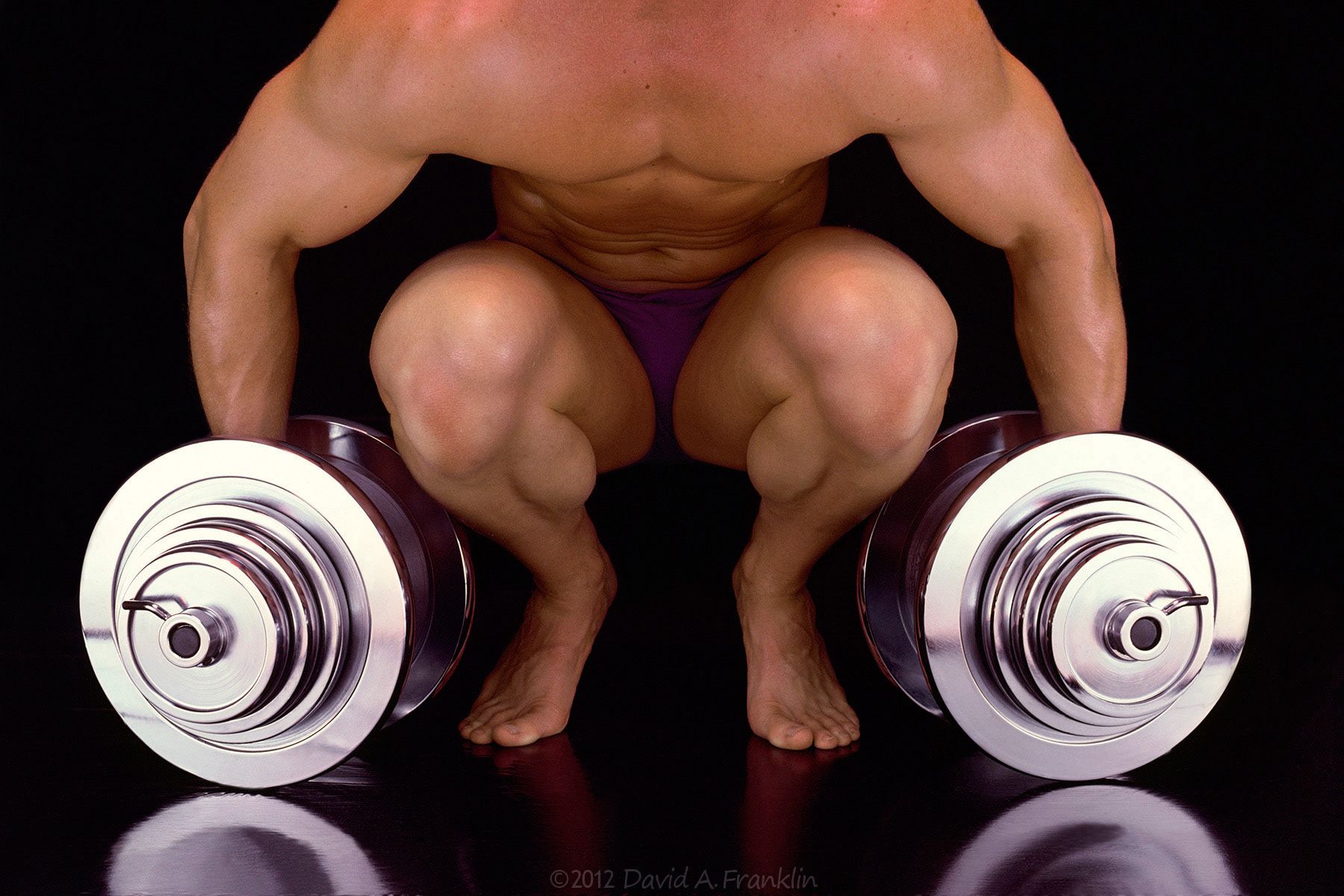 SquattingBodyBuilder_LiftingDumbbells_Editorial