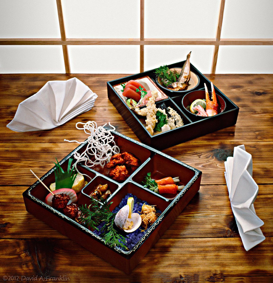 FilledJapaneseLunchBoxes_SetOnWoodTable_BeforePaperScreen_Editorial