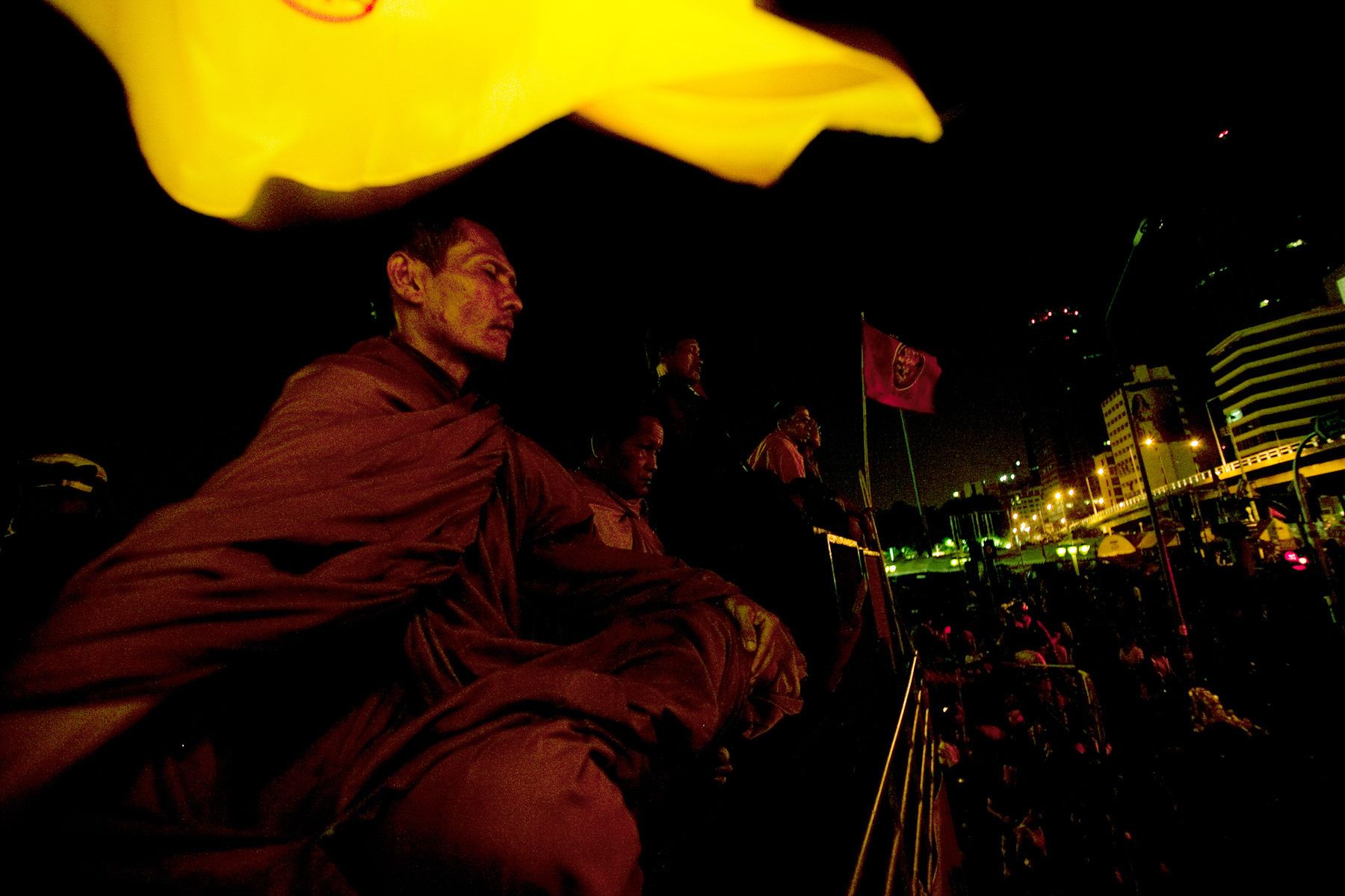 Monks who are members of The United Front for Democracy AgainstDictatorship (UDD) sit and wait for soldiers expected to try to remove their protest camp early that morning.