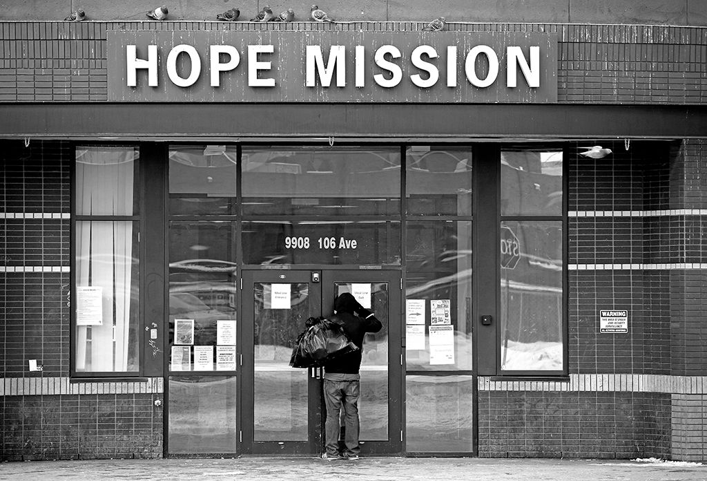 A man peers through the door of the Hope Mission in downtown Edmonton, Canada.