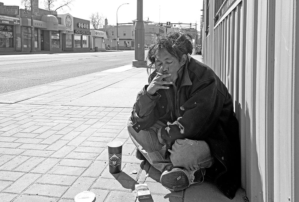 A man smokes a cigarette in the Chinatown district of downtown Edmonton, Canada on May 10, 2021.