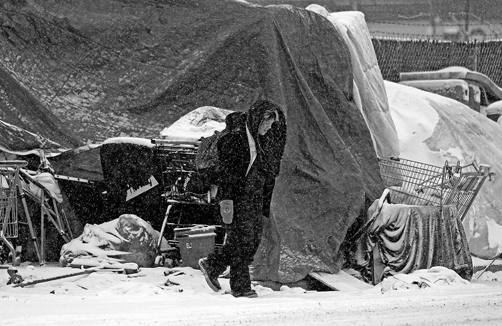 A resident of a homeless encampment in downtown Edmonton, Canada endures the elements on November 30, 2022.